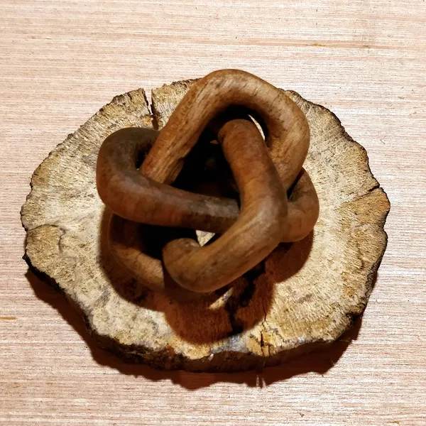 A set of three interlocking rings carved from a single piece of wood. by Wondiu
