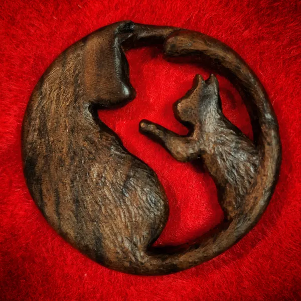 A cat and kitten medallion carved from black walnut. by Wondiu