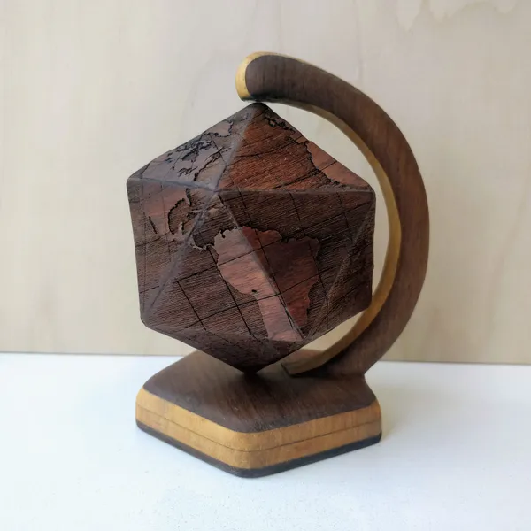 A globe in the shape of an icosahedron, which levitates on a magnetic stand. The globe is made of 20 engraved triangles of black walnut, the stand is made of obeche and black walnut. by Wondiu