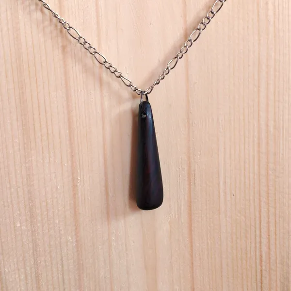 Pendant handcarved from leadwood shaped like a thin drop. by Wondiu
