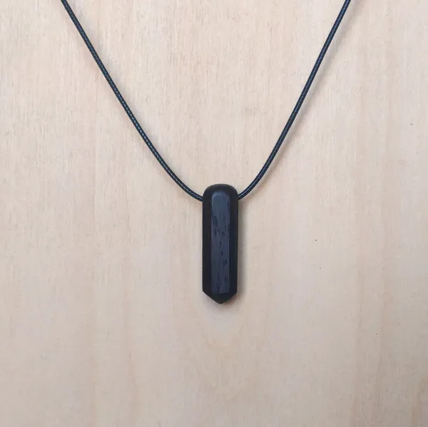Pendant handcarved from leadwood in an octogonal crystal shape. by Wondiu