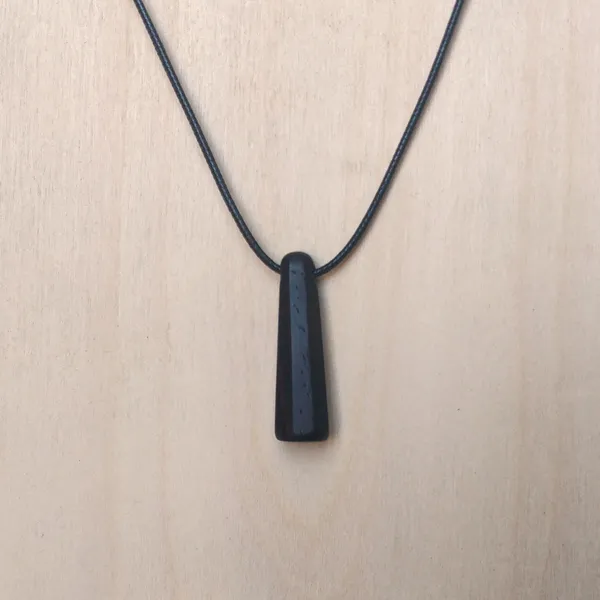 Pendant handcarved from leadwood in an octogonal cone shape. by Wondiu